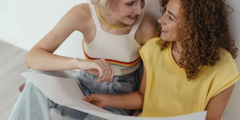 Two Woman Looking At Paper